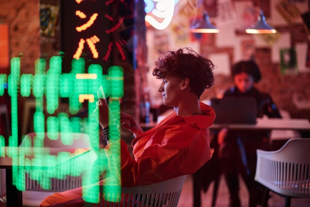 Side view of young man in bomber jacket scrolling on tablet screen