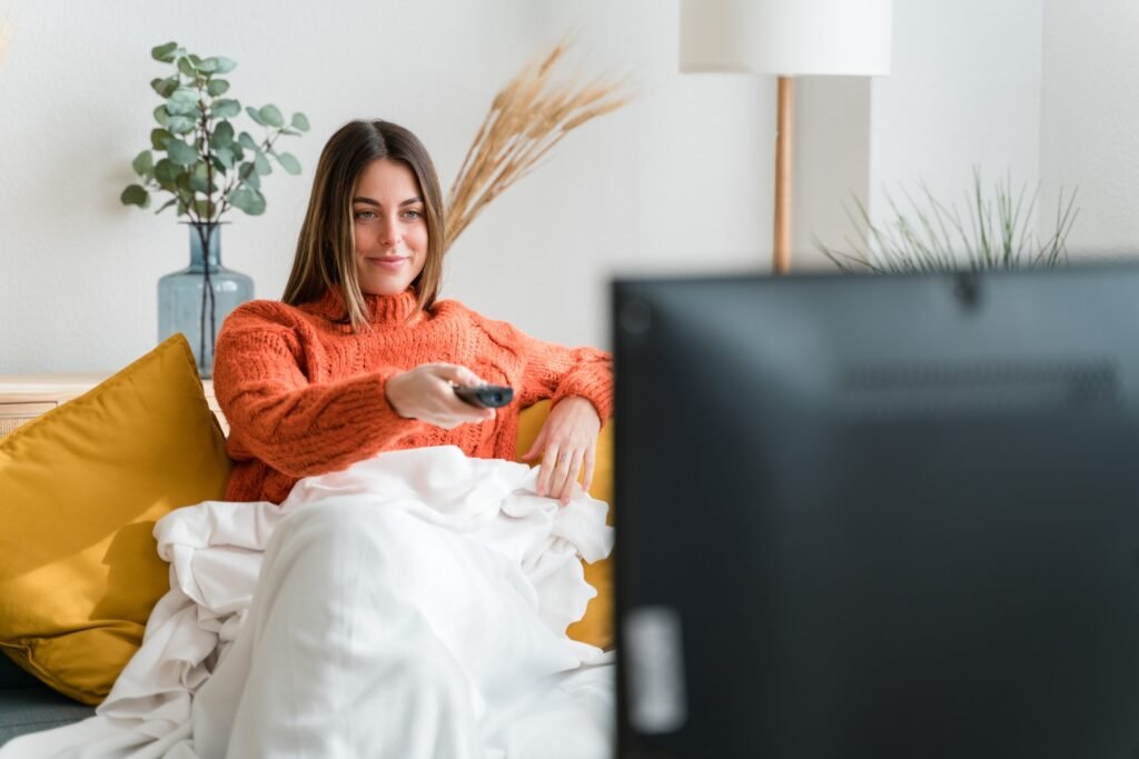 Young woman watching tv in living room